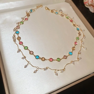 Detailansicht der doppellagigen Goldkette mit bunten Blumenperlen und weißen Perlenanhängern