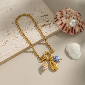 Gold ocean style chain bracelet with seashell pendants and blue ceramic bead