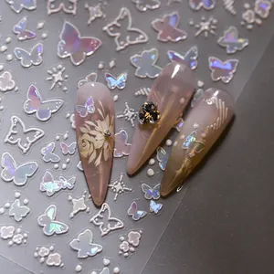 Macro detail of laser butterfly and floral nail stickers on a dark manicured nail