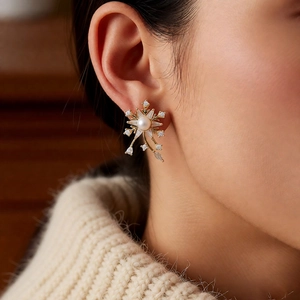 Gros plan de boucles d'oreilles flocon de neige avec perle et zircon sur le mannequin