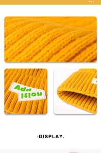 Detail view of bright yellow knitted beanie featuring thick ribbed texture and plastic patches