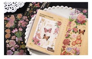 Detail of vintage floral gold foil stickers on a journal with roses and butterfly motifs
