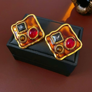 Détail de boucles d'oreilles baroques vintage avec base ambre et cristaux incrustés