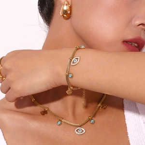 Close-up of 18K gold plated evil eye jewelry set with turquoise beads on model