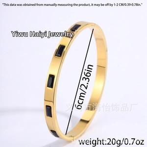 Close-up of golden titanium steel bangle showing 6cm diameter and black rectangle gems