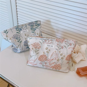 Detail of floral embroidery and shiny sequins on canvas cosmetic storage pouches