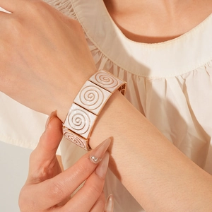 Macro detail of vintage gold bracelet with enamel square links and spiral pattern