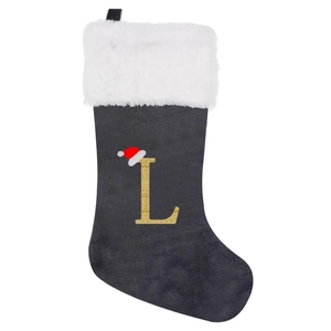 Detail of grey velvet Christmas stocking with gold glitter letter L and white faux fur trim