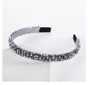 Detail of multi-row grey crystals on a silk fabric headband with modern stone support