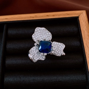 Vue détaillée d'une bague fleur vintage avec zircon bleu carré dans un écrin en bois