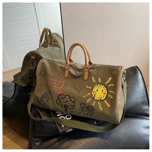 Army green canvas travel bag featuring colorful doodle prints and brown leather handles