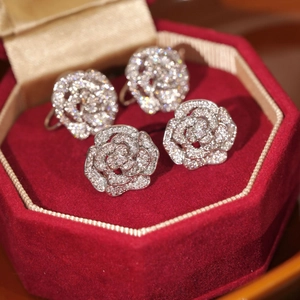 Détail de boucles d'oreilles camélia argentées avec zircons dans un écrin en velours