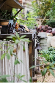 Detail of vintage cast iron bird doorbell mounted on wood in a rustic garden setting