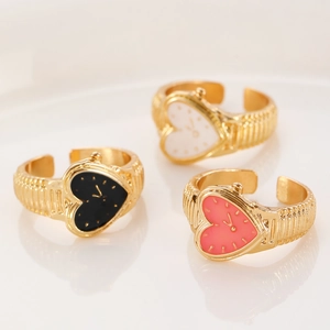 Macro detail of gold watch rings featuring heart-shaped dials and textured bands