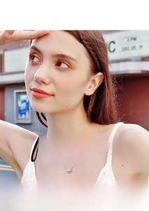 Close-up of emerald cut pendant necklace on model with minimalist silver chain style