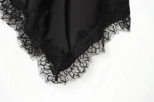 Detailed view of black satin fabric featuring exquisite eyelash lace trim and refined texture