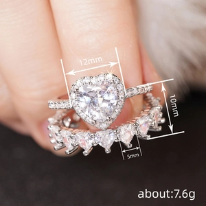 Elegant heart-shaped wedding ring set with sparkling zircons worn on finger