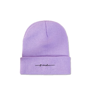 Détail du bonnet en tricot lilas avec broderie cursive Freedom noire sur le revers