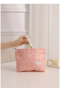 Close-up of pink leopard print cosmetic bag with metal zipper and H&R logo tag