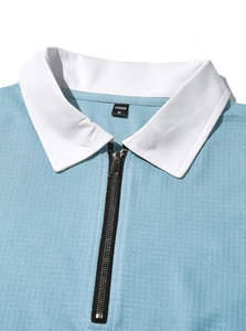 Detail of light blue knit polo collar with metal zipper and white contrast trim