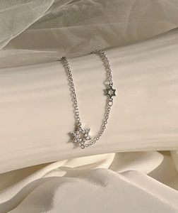 Close-up of sparkling star-shaped bracelet with pavé zircons and fine silver chain link