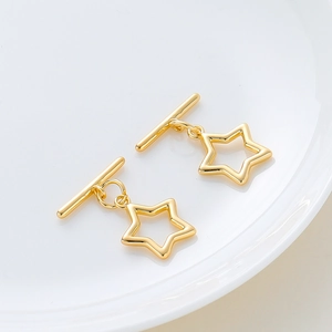 Star dangle earrings with T-bar clasp in 14k gold plated finish on white ceramic tray