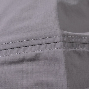 Detail of grey ripstop cotton fabric with durable grid texture and neat double stitching