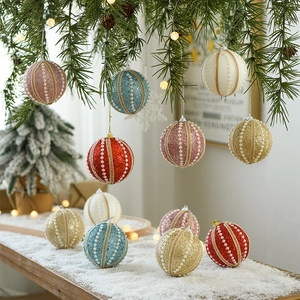 Sparkly Christmas ornaments with pearls on pine branches in a warm snowy holiday setting