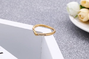 Bague élégante en V dorée ornée de strass blancs brillants sur un support géométrique