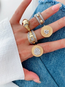 Close-up of dual-tone 18K gold plated rings with horseshoe and rhinestone details on hand