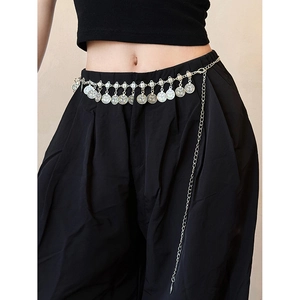 Détail d'une chaîne de taille en métal argenté avec pendentifs ronds sur un mannequin
