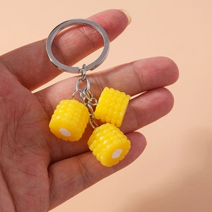 Realistic yellow corn keychain with metallic ring handheld against a clean background