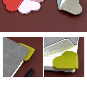 Detailed view of colorful heart-shaped leather bookmarks with fine stitching on a notebook