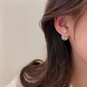 Détail des boucles d'oreilles perles plaquées or avec cristaux carrés portées par un mannequin