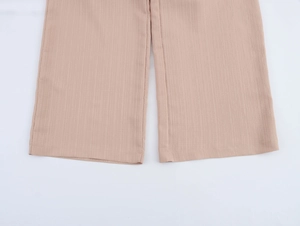 Gros plan détaillé du pantalon large kaki texturé montrant l'ourlet en tissu crêpe