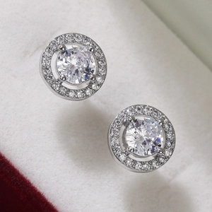 Macro shot of silver halo stud earrings with a central round-cut sparkling zircon
