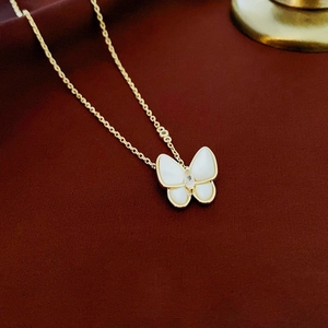 Elegante collana a farfalla dorata con madreperla bianca e zircone su sfondo rosso