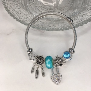 Dettaglio macro del bracciale argento con ciondolo acchiappasogni, stella e perle blu