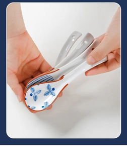 Detail of four ceramic soup spoons with elegant blue leaf patterns and curved handles