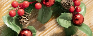 Close-up of Christmas wreath with red berries, pine cones, and green pine needles