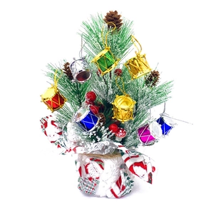 Mini Christmas tree with colorful laser drums, pine cones and festive berries ornaments