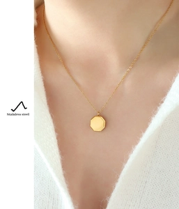 Detail of a minimalist gold octagonal pendant necklace made of high-quality stainless steel