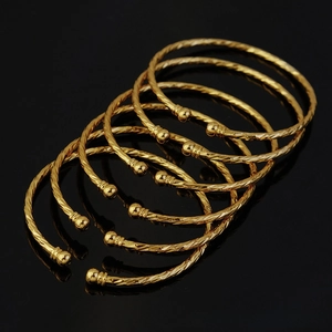 Detail view of 6-piece 3mm gold-plated twisted bracelets with spherical beads for weddings