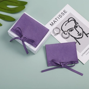 Detailed view of purple velvet jewelry pouches with bow ties and white square gift box