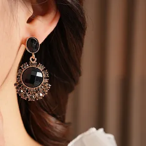 Boucles d'oreilles dorées de style vintage avec grandes pierres noires et accents gris