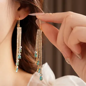 Elegant gold tassel earrings with light blue water drop gemstones and zircon chain fringe