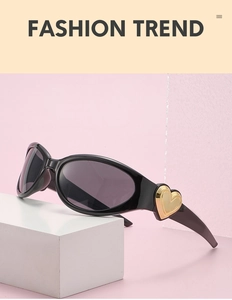Close-up of black Y2K sunglasses with distinctive gold heart detail on the temple