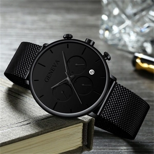 Detail of Geneva black mesh band watch with calendar window on a vintage book setting