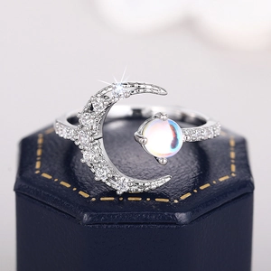 Detailed view of crescent moon ring with iridescent moonstone and pavé diamonds