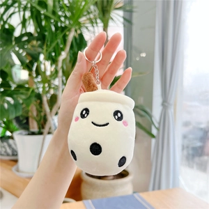 Detail of a plush bubble tea keychain featuring a smiling face and a brown straw